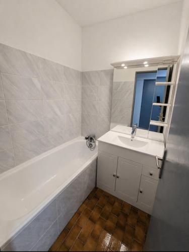 a bathroom with a white tub and a sink at Apparte 104 avec Jacuzzi in Cap d'Agde
