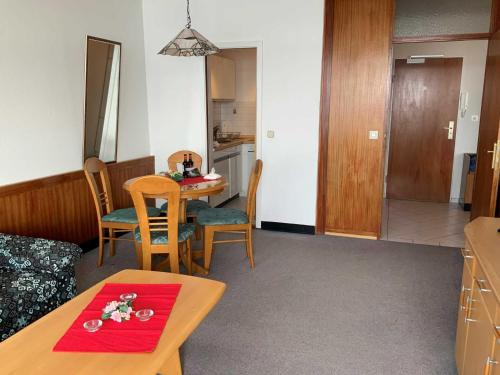 a living room with a table and a kitchen at App_ an der Seepromenade _ Mittels in Malente
