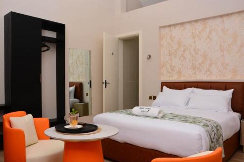 a bedroom with a bed and a table and chairs at Bustani Tulivu in Bungoma