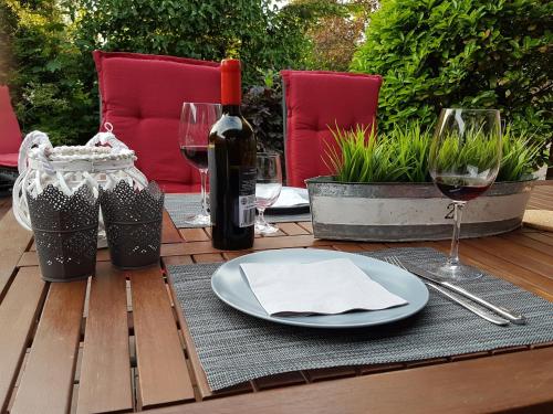 a table with a plate and glasses of wine at Wattliebe Burhave in Burhave