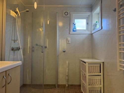a shower with a glass door in a bathroom at Charming house close to Lekens in Skullbru