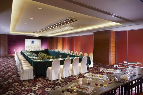 a conference room with a long table and white chairs at Grand Park Wuxi in Wuxi