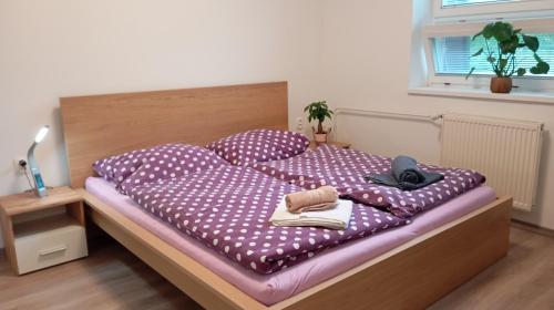 a bed with polka dot sheets and shoes on it at Apartmán Istebné in Istebné