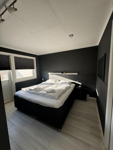 a bedroom with a bed with a black wall at Apartment close to Leknes airport in Leknes