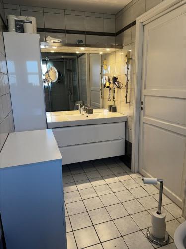 a bathroom with a tub and a large mirror at Apartment close to Leknes airport in Leknes