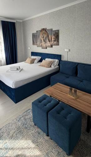 a bedroom with a bed and a couch and a table at MEIMAN hotel in Aktobe