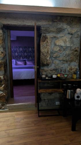 a bedroom with a bed and a stone wall at Casa rural Mirador, Balneario Histórico de Cortegada in Cortegada