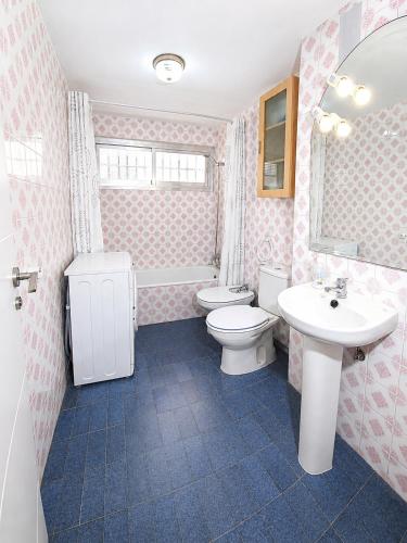 a pink bathroom with a toilet and a sink at Vacansis Apartamento Cullera Mar in Cullera