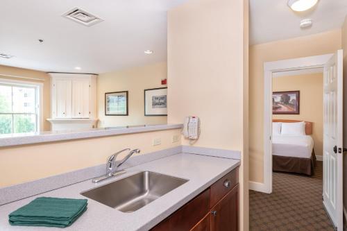 a kitchen with a sink and a bed in a room at Jackson Gore Village, A Vail Resorts Property in Ludlow