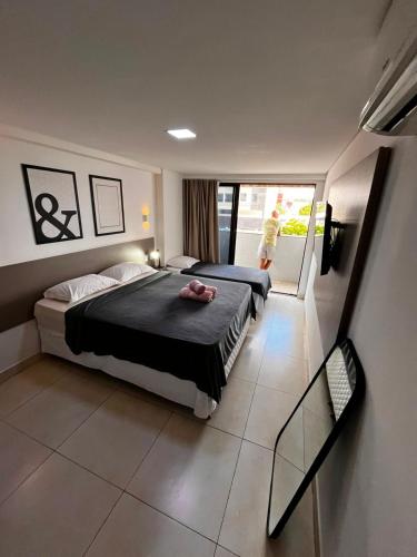 a bedroom with two beds and a balcony at Flat Manaira in João Pessoa