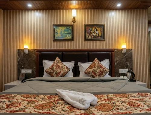 a bedroom with a large bed with pillows at Hotel Red Rose in Darjeeling