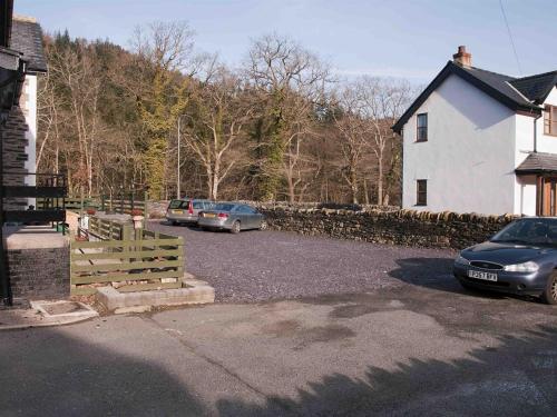 two cars parked in a parking lot next to a house at Oakfield House Bed and Breakfast in Betws-y-coed