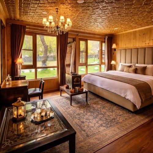 a bedroom with a bed and a desk and a table at River Retreat Resort in Pahalgām