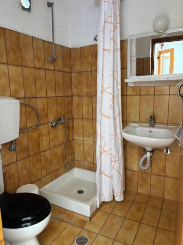 a bathroom with a toilet and a sink and a shower at Pasiphae - Rooms for rent in Agia Galini