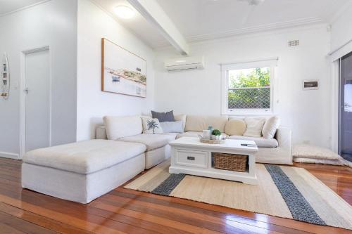 a living room with a couch and a table at Summer Breeze Lake House in Forster