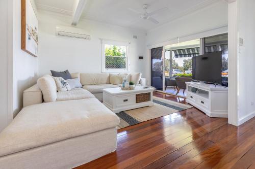 a living room with a couch and a tv at Summer Breeze Lake House in Forster