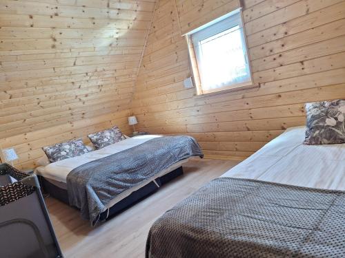 a bedroom with two beds in a log cabin at Morskie Sarbinowo in Sarbinowo