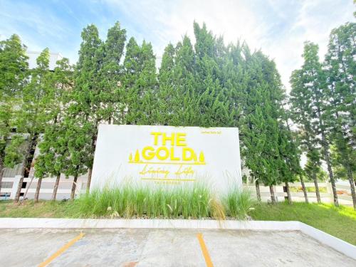 a sign in a parking lot with trees in the background at The Gold Living Life in Thung Song
