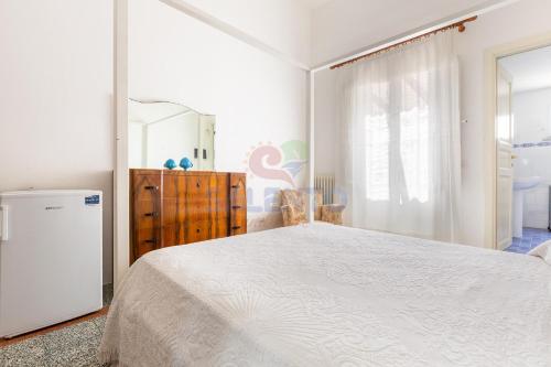 a bedroom with a large white bed and a dresser at Palazzo del Borgo Salentino in Acquarica del Capo