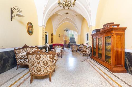 a living room with chairs and a chandelier at Palazzo del Borgo Salentino in Acquarica del Capo