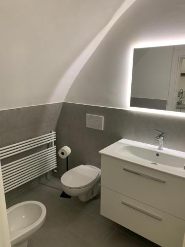 a bathroom with a white toilet and a sink at Casa Paola in Spello