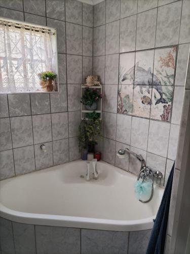 a bath tub in a bathroom with a window at Anchors Aweigh in Hibberdene