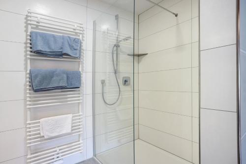 a bathroom with a glass shower with blue towels at Ferienwohnung Trendelmühle Lautrach in Lautrach