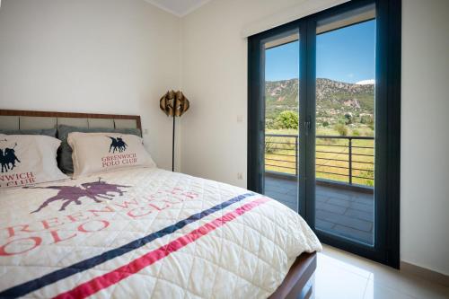 a bedroom with a bed and a large window at Gaia Villa in Thesprotikón