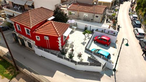 a red house with a red car parked in front of it at LV Luxury Apartment in Parga