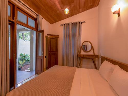 a bedroom with a bed and a large window at The Calm boutique Villa in Ahangama