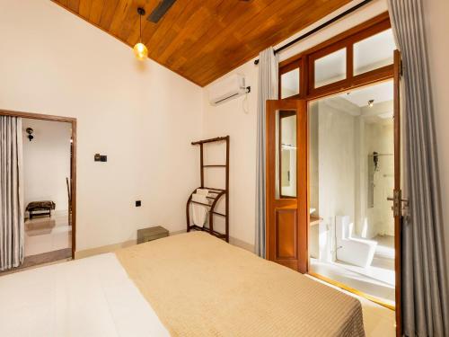 a bedroom with a bed and a sliding glass door at The Calm boutique Villa in Ahangama