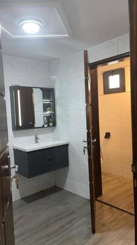 a bathroom with a sink and a mirror and a door at Immeuble cgk in Cocody