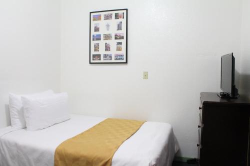 a hotel room with a bed and a flat screen tv at Union Hotel in San Francisco