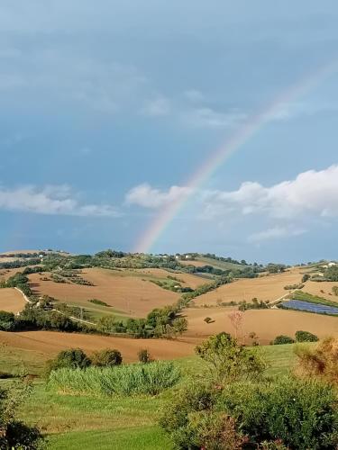 a rainbow in the sky over the rolling hills at Casa Rustica mit privatem Pool zur alleinigen Nutzung in Corinaldo