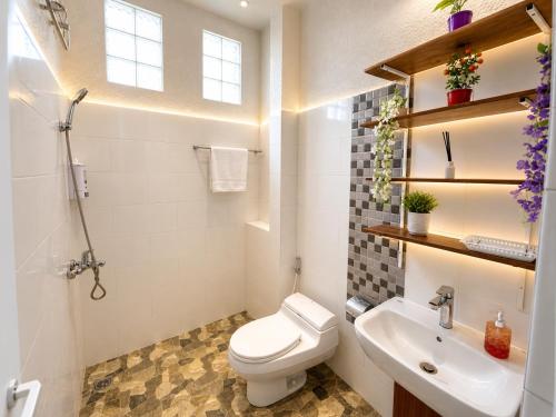 a bathroom with a toilet and a sink at Holi Saren Guest House in Nusa Dua