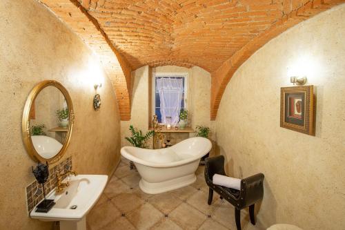 a bathroom with a tub and a sink and a mirror at Rezydencja Grawert Boutique & Spa in Lądek-Zdrój