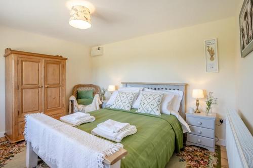 a bedroom with a green bed with towels on it at 3 Bed in Bassaleg oc-bow138 in Bassaleg