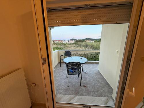 a view from the door of a balcony with a table and chairs at Apartment Deniz in Nea Peramos