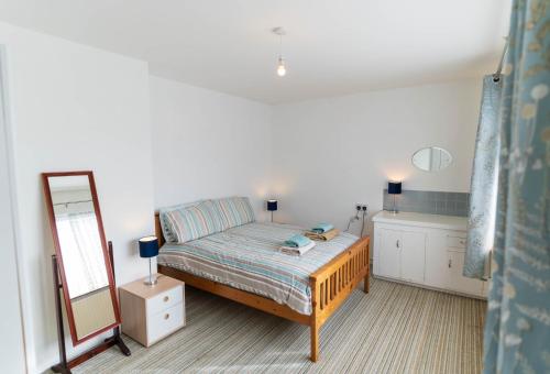 a small bedroom with a bed and a mirror at Sneem Townhouse in Sneem