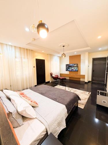 a bedroom with a large bed and a living room at Casa Midelle in Alagbado
