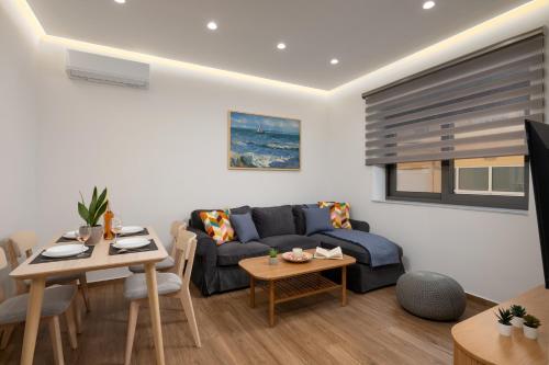 a living room with a couch and a table at Kitron Blue Seaside Luxury Apartment in Agios Nikolaos