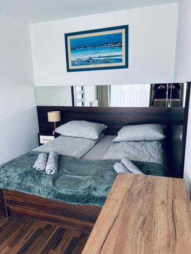 two twin beds in a room with a wooden table at Apartament Atrium Sarbinowo in Sarbinowo