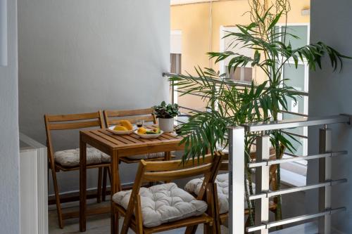 a dining room with a table with chairs and a plant at Kitron Blue Seaside Luxury Apartment in Agios Nikolaos