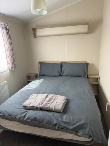 a bed with a towel on it in a bedroom at Challaborough caravan in Burgh Island