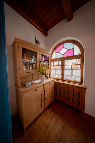 a kitchen with a stained glass window and wooden cabinets at Azuria Viscri in Viscri