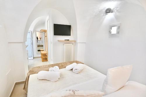 a white room with a bed and a tv at Il Rifugio Dei Nonni in Ostuni