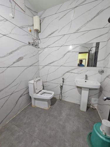 a bathroom with a toilet and a sink at Arya Palace in Phulabāni