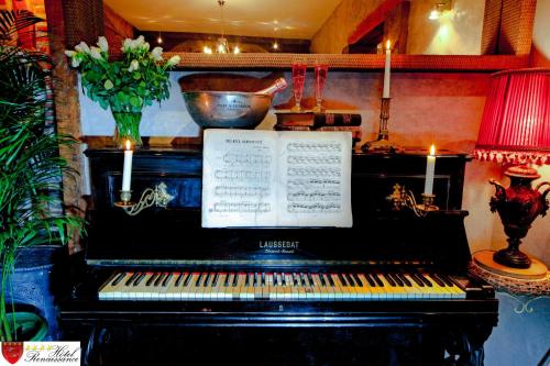 a piano in a room with candles on it at Hôtel Renaissance in Castres