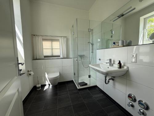 a white bathroom with a sink and a toilet at Schonekind Appartement Soest in Soest