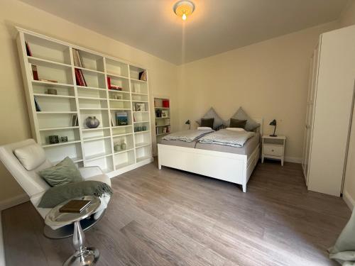 a bedroom with a bed and a couch and a chair at Schonekind Appartement Soest in Soest